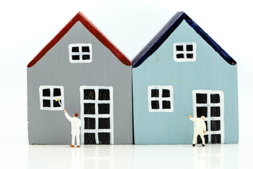 Miniature people : Workers painting a  Mini house, art, money, finance, business concept.