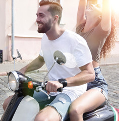 Happy young couple having fun on a scooter