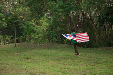 Independence Day concept. A happy bog holding Malaysian flag.
