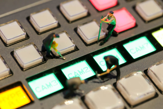 Miniature people : worker on Switcher buttons in studio TV station, Audio and Video Production Switcher of Television Broadcast.