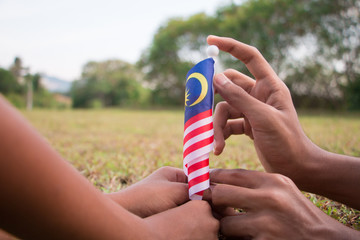 Independence Day concept. Kids' hands holding Malaysian flag.