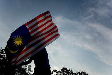 Independence Day concept. A happy and proud citizen holding Malaysian flag.