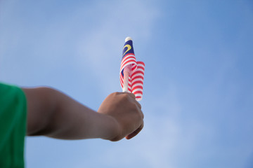 Independence Day concept. A happy and proud boy holding Malaysian flag.