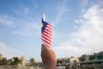 Independence Day concept. A happy and proud boy holding Malaysian flag.