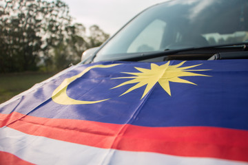 Independence Day concept - Malaysian flag on Malaysian car.