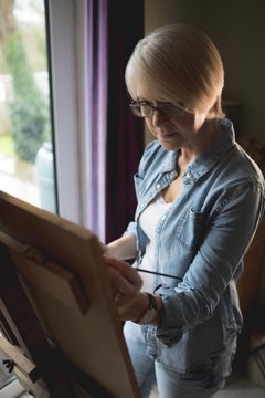 Female artist painting on a canvas with a paintbrush