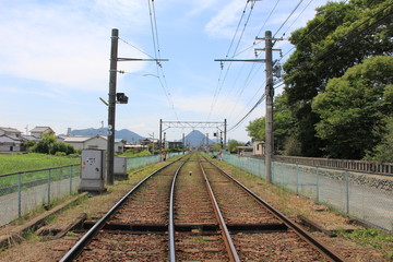 線路の先に綺麗な三角形の山が見える風景(香川県)