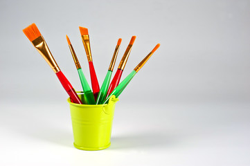 Paint brushes of various shapes and widths with bright plastic handles