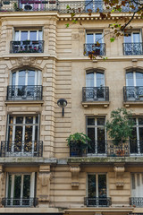 Obraz premium Old Paris residential buildings with balconies and flowers. Beautiful facade of typical french city house. Background. European architecture and city life, lifestyle and expensive real estate concept