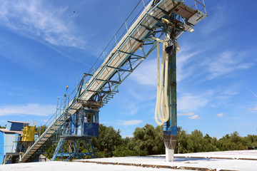 Fototapeta na wymiar Conveyor belt loading ore into a capesize bulk carrier
