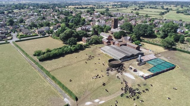 Aerial view, panning movement. Old settlement, Tarvin, church tower, farm and housing.