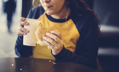Close up of teenage girl eating hamburger obesity concept - obrazy, fototapety, plakaty