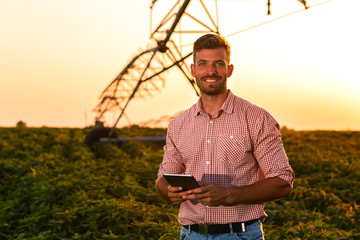 Young farmer in filed holding tablet in his hands and examining soybean corp. © Zoran Zeremski