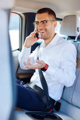 On the phone. Cheerful delighted businessman discussing work while going to the office