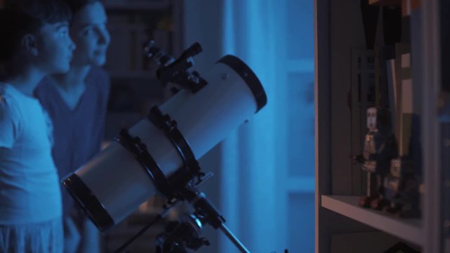 Sisters watching stars together with a professional telescope