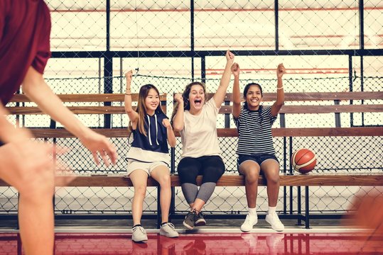 Teenage Girls Cheering The Boys Playing Basketball