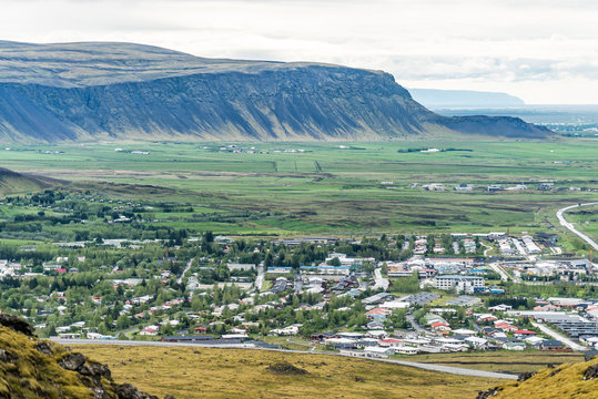Aerial view down of Hveragerdi, Iceland town, city or village with houses, cityscape or skyline landscape, mountain cliff, in valley