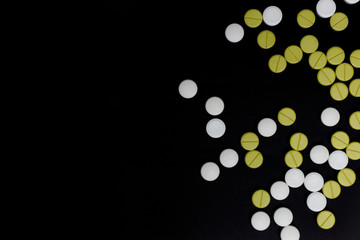 white and green pills on black background