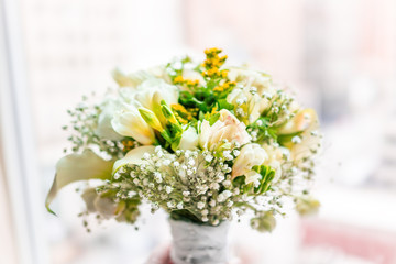 Closeup of flower bouquet pink tone in front of bright sunny window in room of hotel, many flowers arrangement