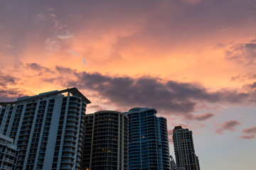 Fototapeta na wymiar Sunny Isles Beach, USA cityscape cloudscape skyline looking up perspective of apartment hotel buildings during colorful sunset evening in Miami, Florida with skyscrapers urban exterior