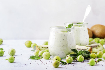 Smoothies from gooseberry, kiwi and yogurt with chia seeds, gray background, selective focus - obrazy, fototapety, plakaty