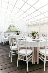 Serving tableware on a table with fresh flowers on a white tablecloth in the restaurant