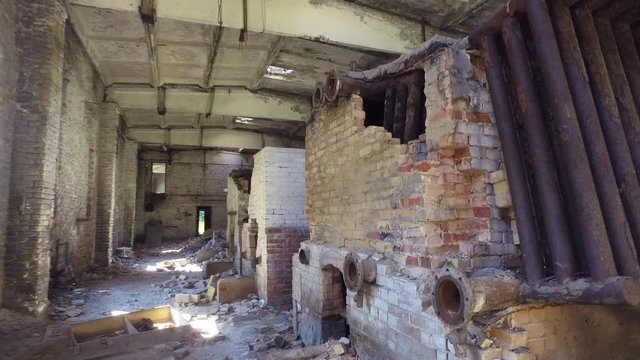 old abandoned and destroyed boiler room. brick walls and broken boiler equipment, garbage.