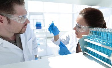 Fototapeta premium close up.two researchers look at the liquid in the test tube