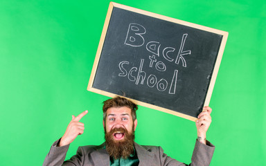Check this out. Offer for pupils. Back to school special offer. Special offer discount and sale school season. Man bearded teacher holds blackboard back to school inscription on green background