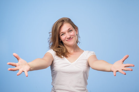 European Woman Raised Up Palms Arms Hands At You, Isolated Over Blue Background.