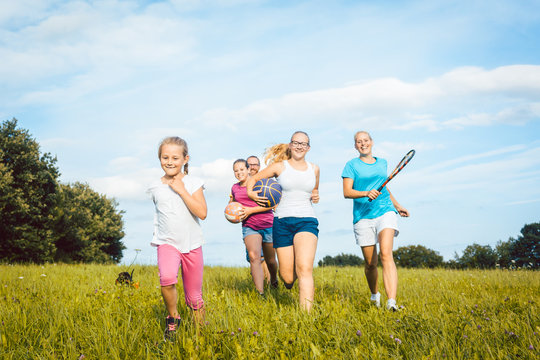 Family playing, running and doing sport in summer landscape