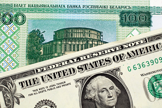A close up image of a Belorussian 100 ruble note with an American one dollar bill