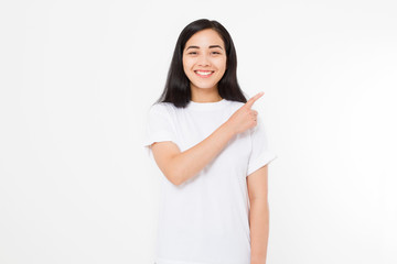 Portrait of smiling young asian woman wearing summer t shirt pointing at copy space by finger isolated on white template and blank background.