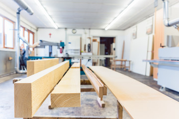 Workshop of a carpenter or joiner with wood in the foreground 