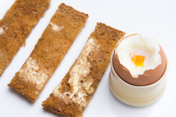 Soft boiled eggs with toast on a white plate. Breakfast