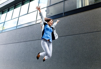 Success, cheerful businesswoman jumping on street.