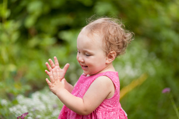 Portrait of cute little girl in summer garden