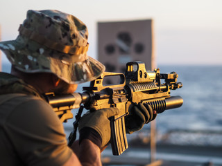 Military soldier aiming with a rifle