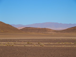 Fototapeta na wymiar Sandy desert at high ATLAS MOUNTAINS range landscapes in MOROCCO
