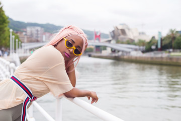 Young influencer girl visiting the city of Bilbao, Basque Country, Spain. On a cloudy morning.