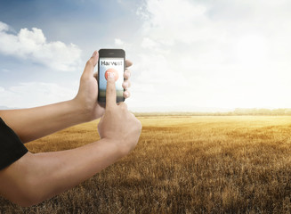 Man with smartphone on dry grass field