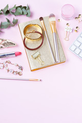 Flat lay home office workspace - female diary with accessories and keyboad, copy space on pink background
