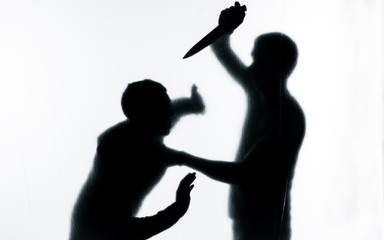 Self-defense battle silhouette. A man fights against an aggressor with a knife. Fight for life against terrorists