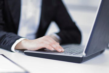 closeup of business woman typing on a laptop
