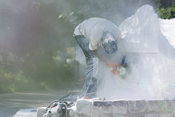 The worker performs grinding work on the monument in the park.