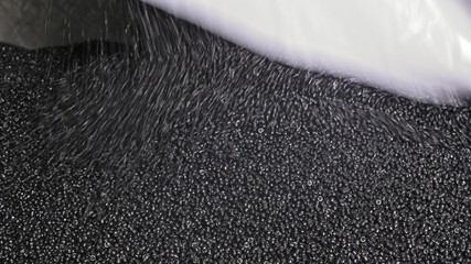 Plastic black gray granulated crumb. Manufacture of plastic water pipes of the factory. Process of...