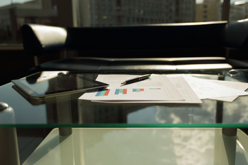 digital tablet, financial chart and pen on the coffee table