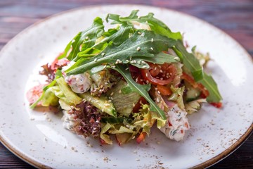Fresh salad with arugula with cottage chees, cherry and pesto sauce