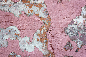 Concrete wall with old cracked pink paint. Texture and background