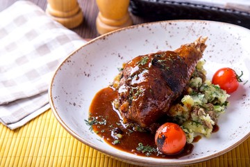 Tasty turkey leg in sauce with garnish in a plate. Space for text. Copyspace